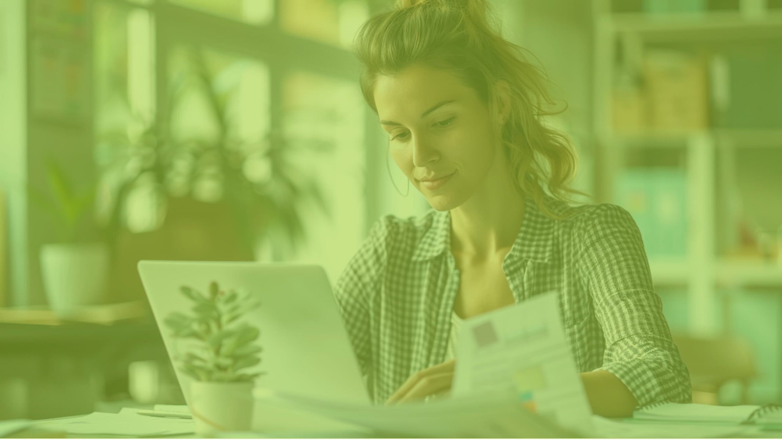 Woman marketing lead reviewing performance reports on a laptop in a bright office.